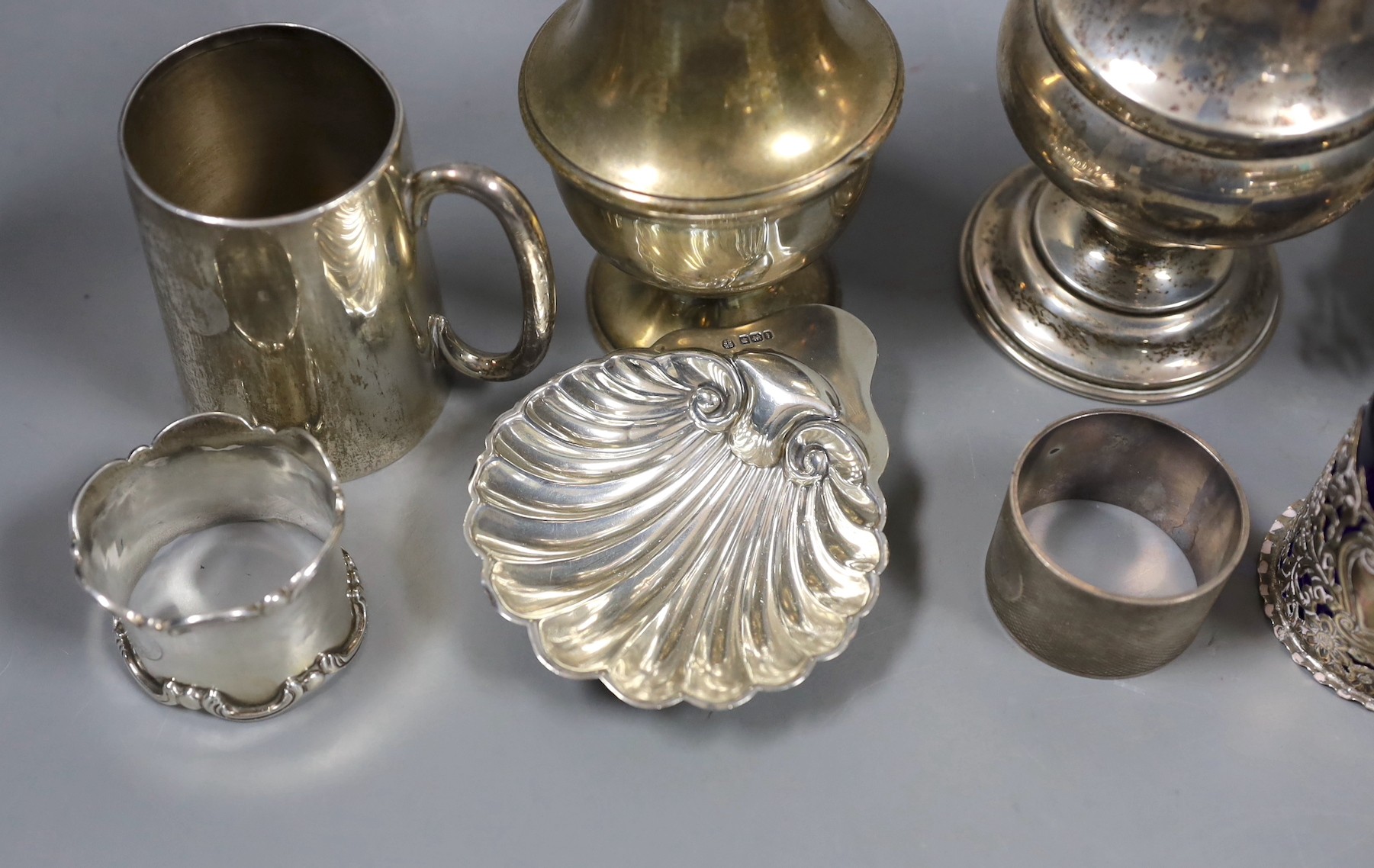 Sundry small silver including two sugar casters, tallest Chester, 1922, 21cm, two mugs, match sleeve, quaich, wine label and three napkin rings